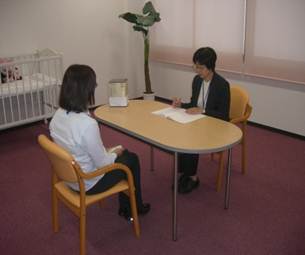 オレンジルーム(被害者専用打合せ室)において女性被害者支援員が相談を受けている様子